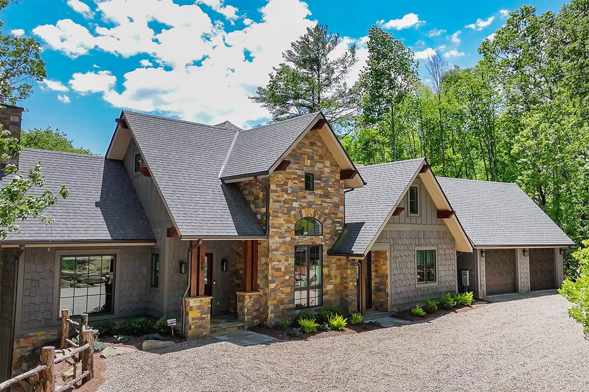 Custom mountain home with log and timber frame architecture, natural stone accents, scenic forest se.
